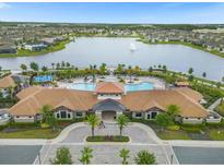 Stunning aerial view of a community pool, clubhouse, and lake surrounded by beautiful homes at 2621 Amati Dr, Kissimmee, FL 34741