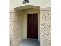 Inviting front entrance with a dark wood door, stone accents and an arched doorway at 2737 Club Cortile Cir, Kissimmee, FL 34746