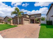 Beautiful home featuring a paver driveway, a two car garage, and manicured lawn at 3159 Somerset Park Dr, Orlando, FL 32824