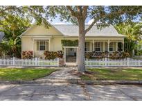 Charming yellow home with a white picket fence and lush landscaping at 3349 Schoolhouse Rd, Harmony, FL 34773