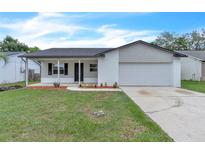 Charming single-story home featuring a well-maintained lawn and an attached two car garage at 5627 Marvell Ave, Orlando, FL 32839