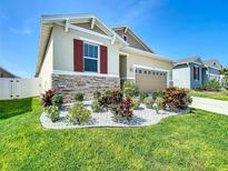 Charming single-story home boasts stone accents, a two-car garage, and a manicured lawn at 591 Lake Smart Blvd, Winter Haven, FL 33881