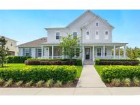 Charming two-story home with a covered porch and professionally landscaped front yard at 7400 Estuary Lake Loop, Celebration, FL 34747