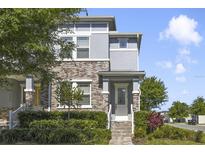 Charming townhome featuring a brick facade, well-manicured landscaping, and a welcoming entryway at 8042 Glenlloyd Ave, Winter Garden, FL 34787