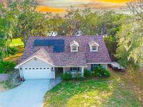 Charming single-Gathering home featuring solar panels, dormer windows, a well-manicured lawn, and two car garage at 822 S Breen Rd, Lake Wales, FL 33898