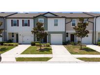 Charming townhomes featuring individual driveways, attached garages and green spaces at 1113 Merrill St, Davenport, FL 33837