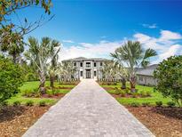 Stunning two-story home featuring a grand entrance, lush landscaping, and a beautiful grey paver driveway at 15121 Pendio Dr, Montverde, FL 34756