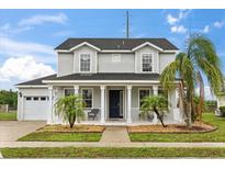Charming two-story home with a welcoming front porch and well-manicured landscaping at 2616 Marg Ln, Kissimmee, FL 34758