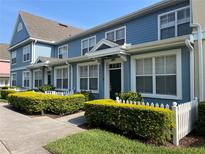 Charming blue townhomes featuring white trim, well-manicured landscaping, and a welcoming curb appeal at 4008 San Gallo Dr # 106, Kissimmee, FL 34741