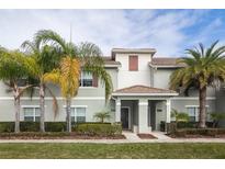 Charming townhome featuring well-maintained landscaping and a welcoming covered entrance at 4875 Clock Tower Dr, Kissimmee, FL 34746