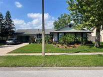 Charming single-story home featuring lush landscaping, manicured lawn, and a welcoming entrance at 4926 Reginald Rd, Orlando, FL 32829