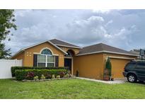 Charming single-story home featuring a well-maintained lawn, complementary landscaping, and an attached two-car garage at 513 Ronshelle Ave, Haines City, FL 33844