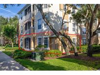 Multi-story condo building showing screened in patio area and manicured landscaping around the base at 6214 Stevenson Dr # 106, Orlando, FL 32835