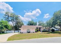 Charming single-story home features a well-manicured lawn and mature trees, creating a serene and inviting atmosphere at 7222 Stanford Dr, Lakeland, FL 33809