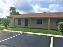 Charming single-story home with a cozy front porch, lush green lawn, and an inviting entrance at 1001 Plantation Dr # E1, Kissimmee, FL 34741