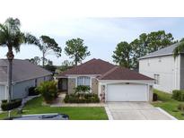 Charming single-story home featuring a well-manicured lawn, a two-car garage, and lush landscaping at 1428 Park Pl, Haines City, FL 33844