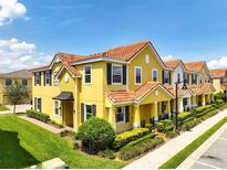 Stunning two-story townhouse with a red tile roof and lush landscaping in a well-maintained community at 14344 Swanley St, Orlando, FL 32832