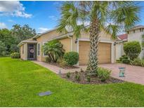 Charming home featuring a well-manicured lawn, palm trees, and a delightful screened-in porch at 1447 Harbor Ridge Drive, Poinciana, FL 34759