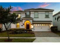 Charming two-story home showcasing a well-manicured lawn, mature tree, and covered entry at 1560 Maidstone Ct, Davenport, FL 33896