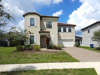 Charming two-story home with a well-manicured lawn and a brick driveway and white window shutters at 191 Aidans Lndg, Haines City, FL 33844