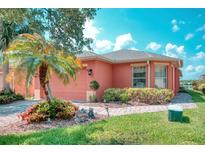 Charming single-story home with well-manicured landscaping, palm tree, and brick walkway at 233 Rialto Rd, Kissimmee, FL 34759