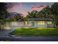 Charming single-story home featuring a lush green lawn, bright green shutters, and a fresh white exterior at 304 W 24Th St, Sanford, FL 32771