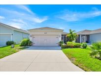 Charming one-story home with a well-manicured lawn and a two-car garage with tropical landscaping at 3193 Whispering Trails Ave, Winter Haven, FL 33884
