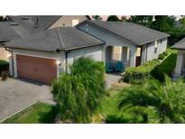 Charming single-story home featuring a well-manicured lawn, a two-car garage, and a covered front porch with seating at 328 Toldedo Rd, Davenport, FL 33837