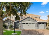 Charming two-story home with a well-manicured front yard and a three car garage with an appealing paver driveway at 3759 Eagle Isle Cir, Kissimmee, FL 34746