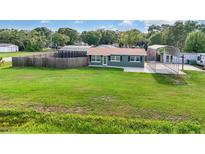 Charming single-story home with a lush green lawn, carport, and fenced backyard offering privacy at 3824 Hickory Tree Rd, St Cloud, FL 34772