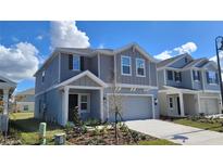Beautiful new construction home with a well-maintained lawn and a covered front entryway at 443 Cool Summer Ln, Davenport, FL 33837