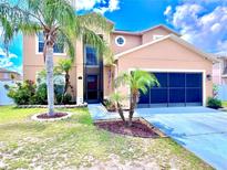 Beautiful two-story home featuring a charming entrance, two-car garage and vibrant tropical landscaping at 4447 Maple Chase Trl, Kissimmee, FL 34758