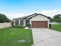 Charming single story home featuring a well-manicured lawn, landscape, and a two-car garage at 5473 Animosh Ct, Polk City, FL 33868