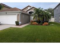 Charming home featuring a manicured front yard with a lovely garden and a two-car garage at 5921 Lake Champlain Dr, Orlando, FL 32829