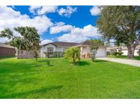 Charming single-story home with well-manicured lawn, mature trees, and lush landscaping at 812 Adour Dr, Kissimmee, FL 34759