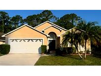 Charming single-story home with a two-car garage, palm trees, and well-manicured lawn at 1006 Soaring Eagle Ln, Kissimmee, FL 34746