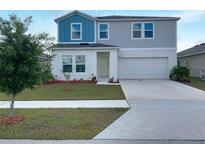 Two-story home with blue and gray siding, white trim, manicured lawn, and a two-car garage at 1404 Axel Cir, Winter Haven, FL 33880