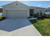 Charming single-story home with a well-maintained lawn and a two-car garage at 200 Citrine Loop, Kissimmee, FL 34758