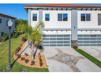 Beautiful modern townhome featuring a red tile roof, glass garage door, and well-manicured landscaping at 2000 Greenbriar Ter, Davenport, FL 33837