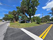 Corner lot view featuring a charming home near Sample Road with lush trees at 2704 Sample St, Kissimmee, FL 34744