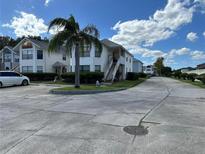 Exterior street view of the property, with palm tree in the front and ample parking space at 2734 Rio Grande Trl # 2734, Kissimmee, FL 34741
