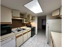 Traditional kitchen with white cabinets, tile floors, and double basin sink at 4905 Sanoma Vlg # Ge, Orlando, FL 32808