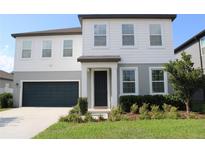 Charming two-story home featuring a well-manicured lawn and an attached two-car garage at 5725 Iron Brand Rd, St Cloud, FL 34771