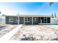 Charming single-story home with gray exterior, screened porch, and well-maintained front yard at 7014 Hershey Way, Orlando, FL 32822