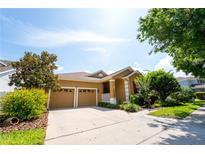 Charming single-Gathering home featuring a two-car garage, manicured landscaping, and a welcoming entrance at 8835 Abbey Leaf Ln, Orlando, FL 32827
