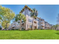 Three-story condo building featuring palm trees and well-maintained landscaping at 1231 Wright Cir # 1213, Celebration, FL 34747