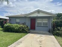 Charming single-story home with a red front door, landscaped with bushes and green grass at 127 Alabama Ave, St Cloud, FL 34769