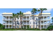 Three-story condo building with balconies and palm trees at 1501 Northern Harrier Way # 202, Reunion, FL 34747