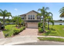 Charming two-story home with a manicured lawn, lush landscaping, and a brick driveway at 15037 Cedar Branch Way, Orlando, FL 32824