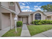 Charming townhome exterior with well-maintained landscaping and an arched window at 1651 Windsor Oak Ct, Kissimmee, FL 34744
